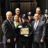 White Plains Police Officer Amy Carelli, center, received her Police Academy training certificate from Commissioner David E. Chong (left of her) and was joined on stage by several family members who also are serving or retired as police officers.