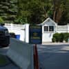 The entrance to the home of Hillary and Bill Clinton can be seen in the background at the end of Old House Lane in Chappaqua. The Secret Service has blocked traffic from driving to the end of the road with concrete barriers.