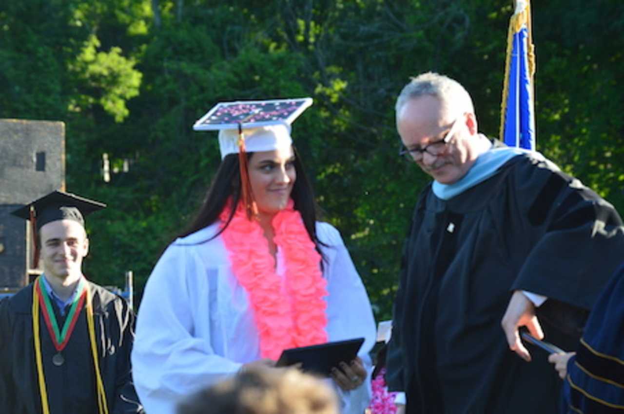 A happy graduate gets her diploma at the Shelton High graduation.