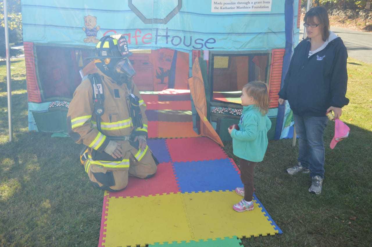 A firefighter shows off his protective gear at the Safe House set up at the open house at the White Hills Volunteer Fire Department in Shelton.