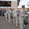 Military members form an assembly line to load vehicles with gifts.