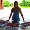 <p>Jessica Smalley sells fresh strawberries from Jones Family Farms at the Shelton Farmers Market.</p>