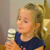 One young baker in the Buttercup Bakery Camp savors her own creation - a cake pop.