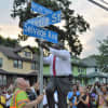Crowd cheering after Teaneck Township Manager William Broughton unveils the new street sign at the corner of Selvage Avenue and Stasia Street.