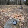 Native stones, each affixed with an aluminum medallion, were placed on identified gravesites.