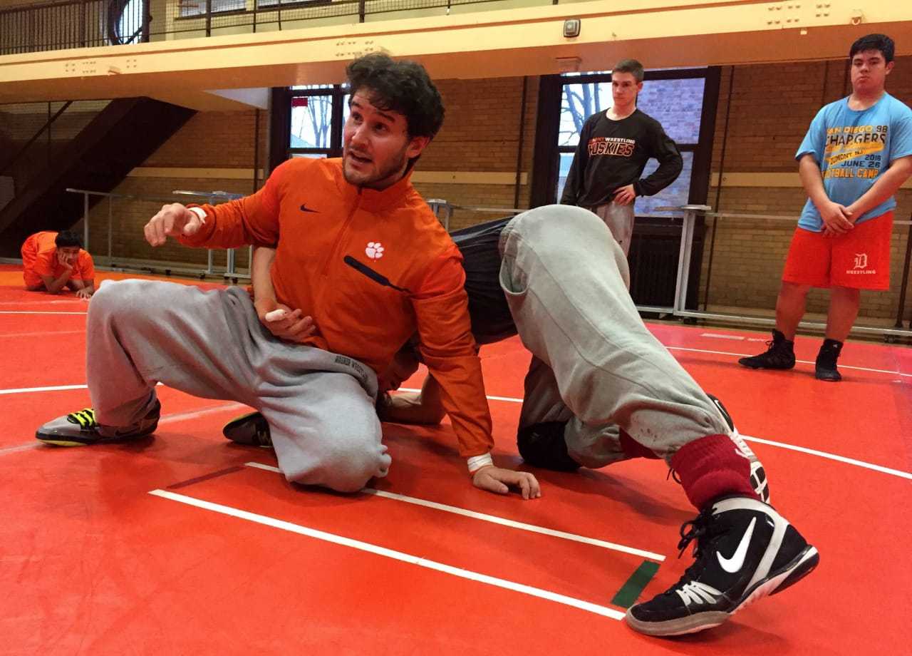 First-year Dumont wrestling coach Mike Rooney works through new skills with senior Mike Vietri.