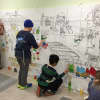Kids painting Betsy Franco Feeney's mural