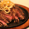 Porterhouse steak for two is topped with fried onions at Joseph's Steakhouse, a restaurant located in a former tearoom in historic Hyde Park.