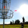 <p>Disc golf is played by throwing golf discs into baskets attached to poles.</p>