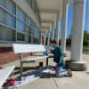 A student paints a bench to show school spirit at Saxe Middle School.