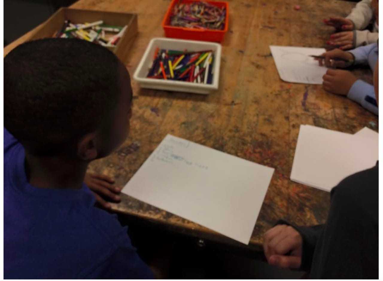 With crayons and paper, children design their egg containers.