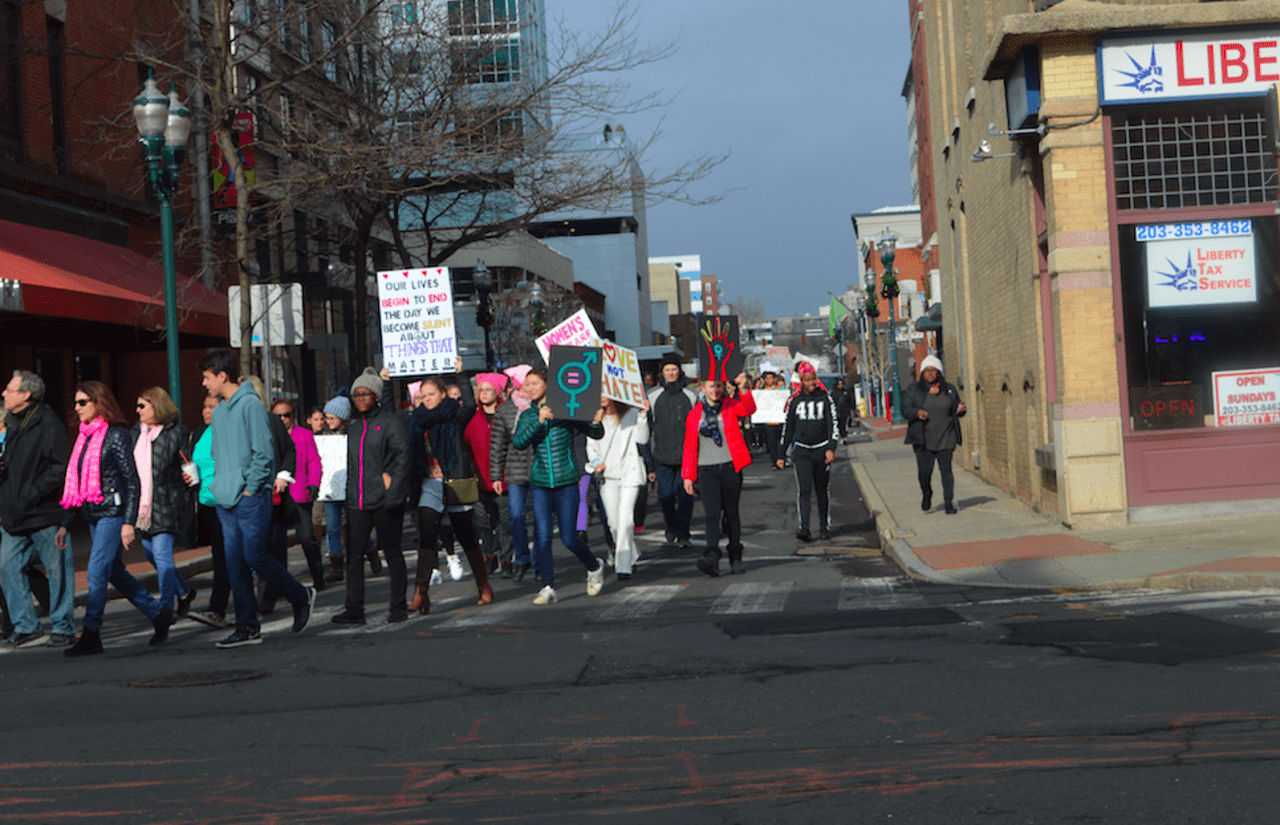 People wave signs and march to have their voices heard in Stamford on Saturday.