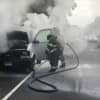 Fire crews douse the inside of a burning cargo van during the Monday morning rush hour on the Merritt Parkway in Fairfield.