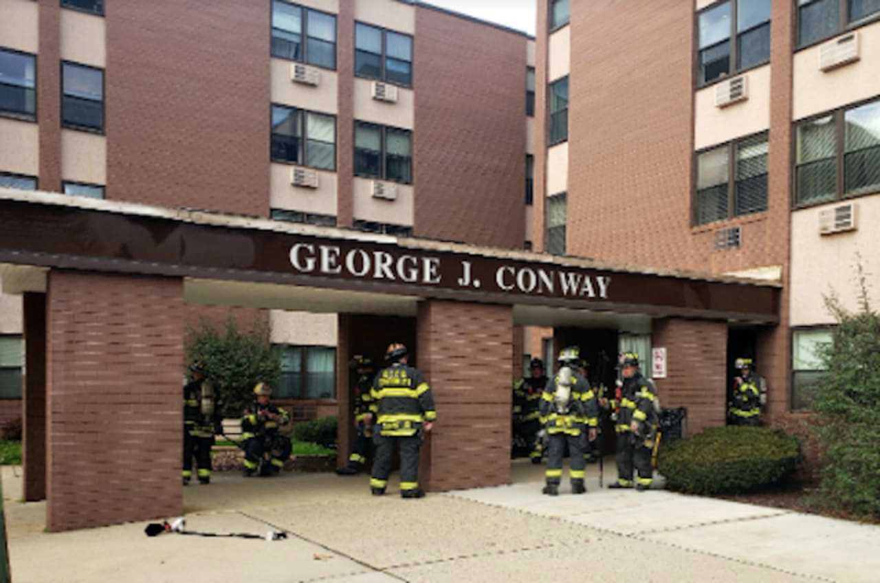 Firefighters enter George J. Conway Towers to battle a third-floor kitchen fire and rescue a tenant.