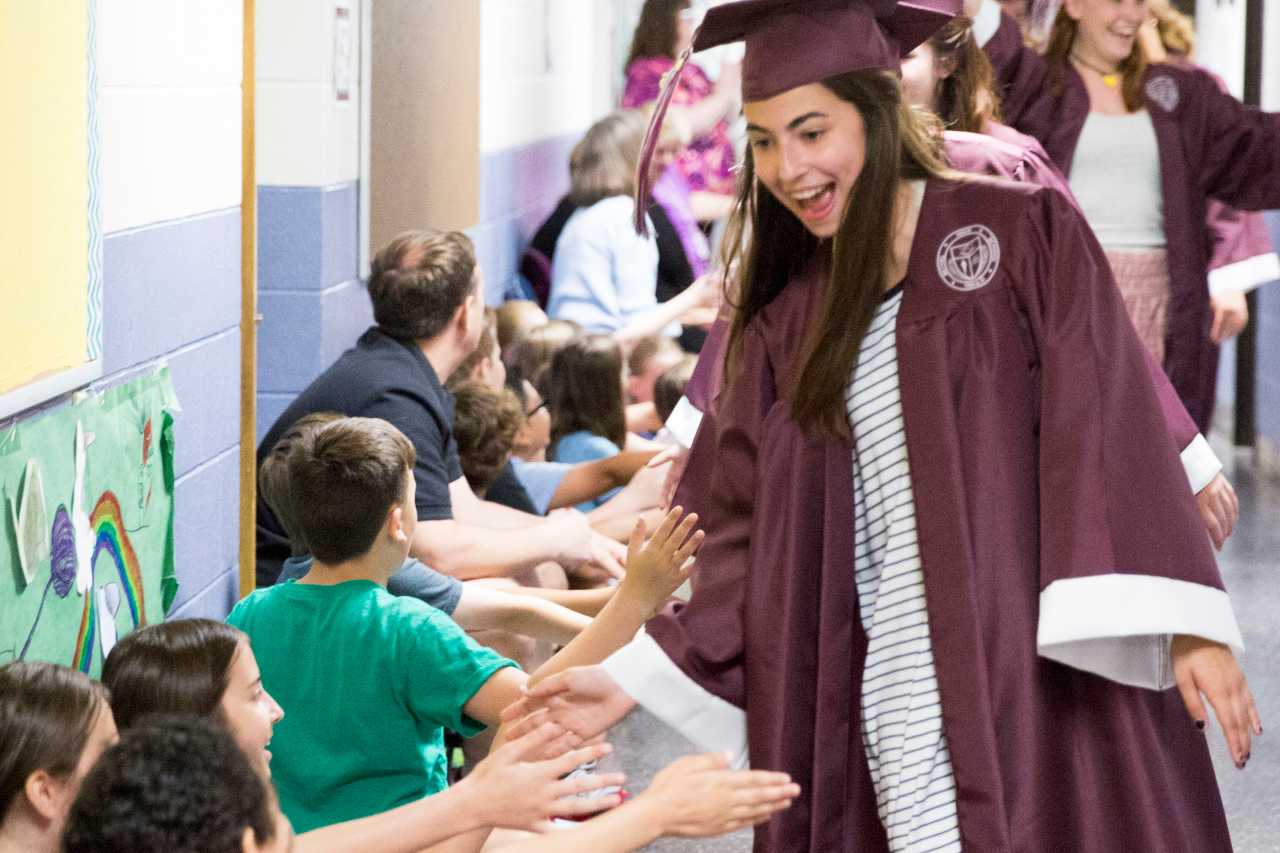 Bethel High School's Amanda Nunes, the senior class President, slaps hands with elementary school children on Thursday.