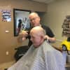 Owner Mark Young with customer Dan Keon, 80, who has been coming to the Buchanan Barbershop since it opened.