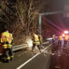 Danbury firefighters cut through a steel guardrail to gain access to a car that went off the highway on I-84