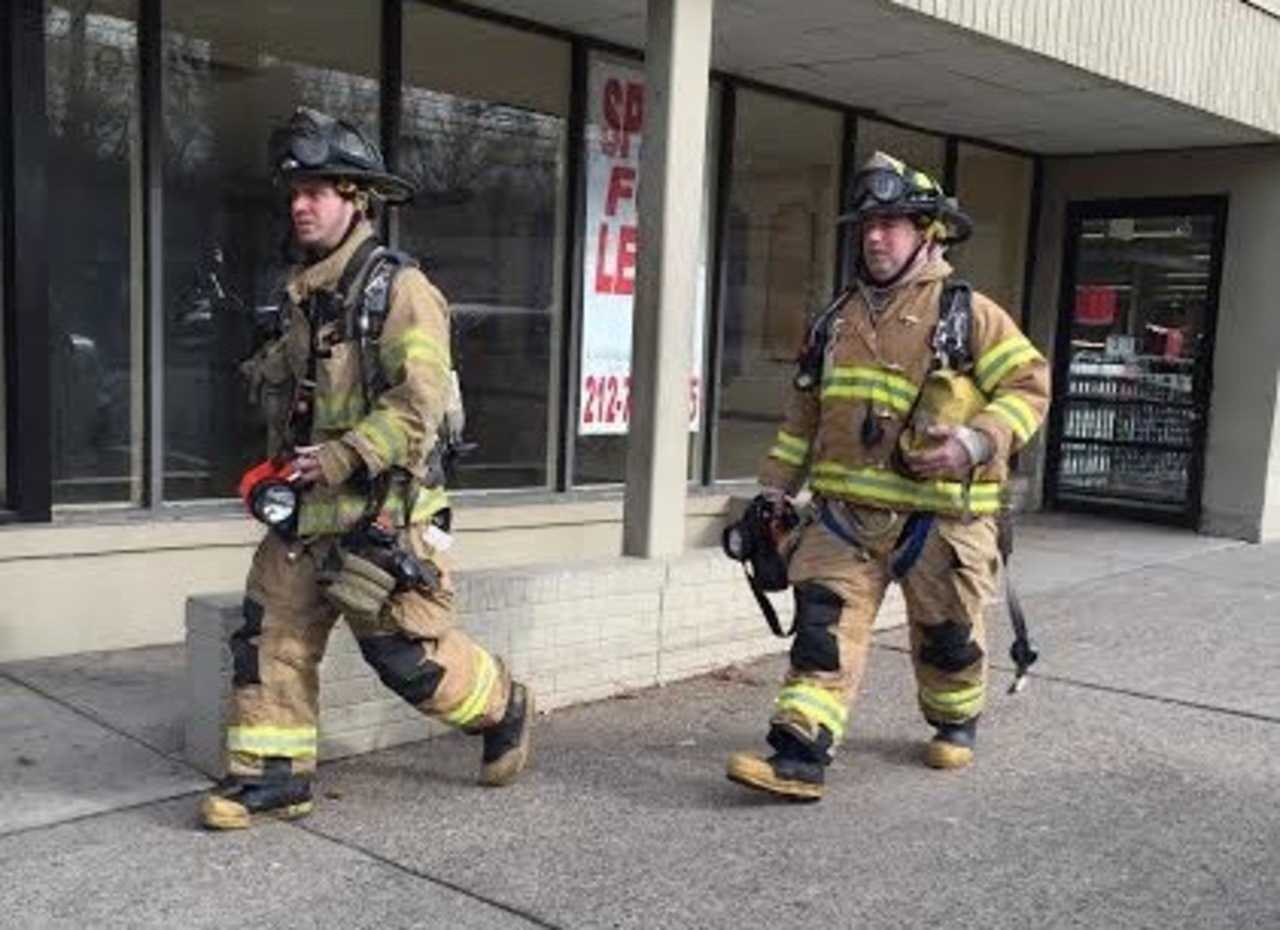 Teaneck firefighters exit Amazing Savings Tuesday morning after responding to a false alarm.