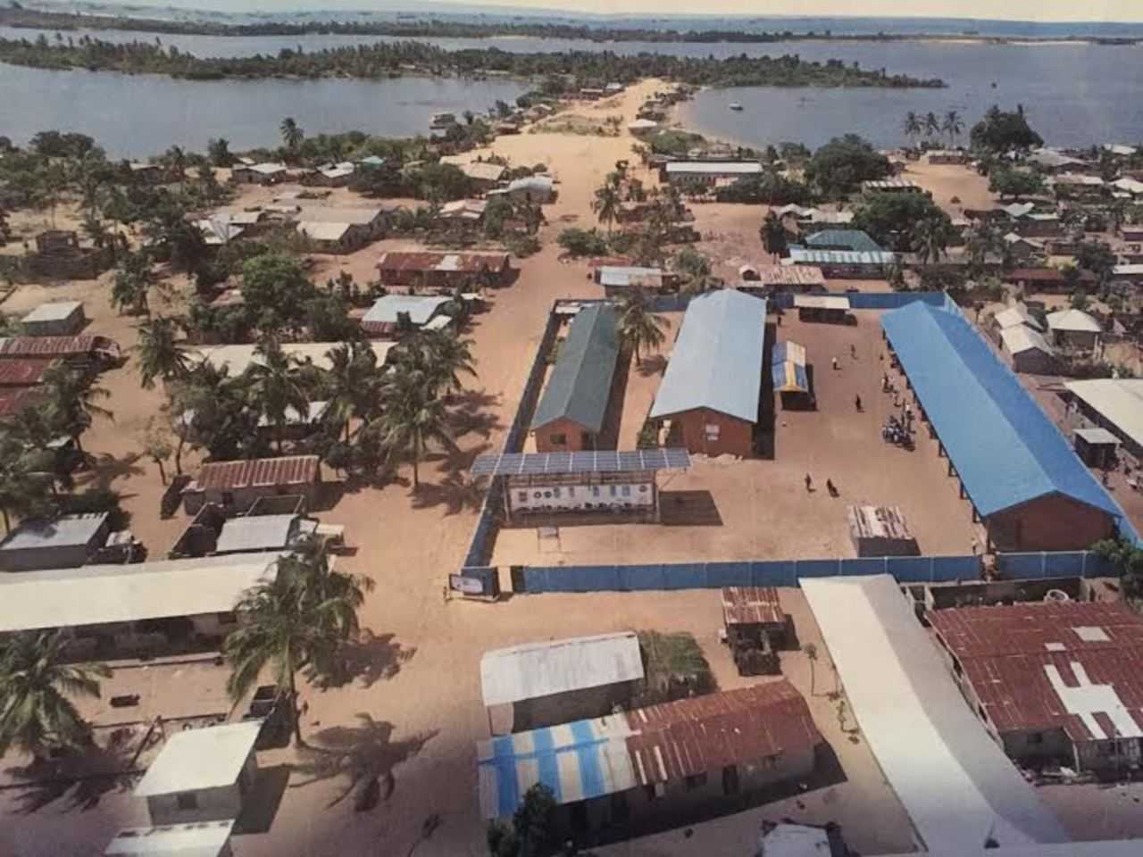 Grushkin's schools, teacher's residence and solar panel are located inside of the blue surrounding wall. The health clinic is located just behind it and to the left.