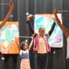Students raise batons during a performance Monday to mark Flag Day at Daniel Webster Elementary School.
