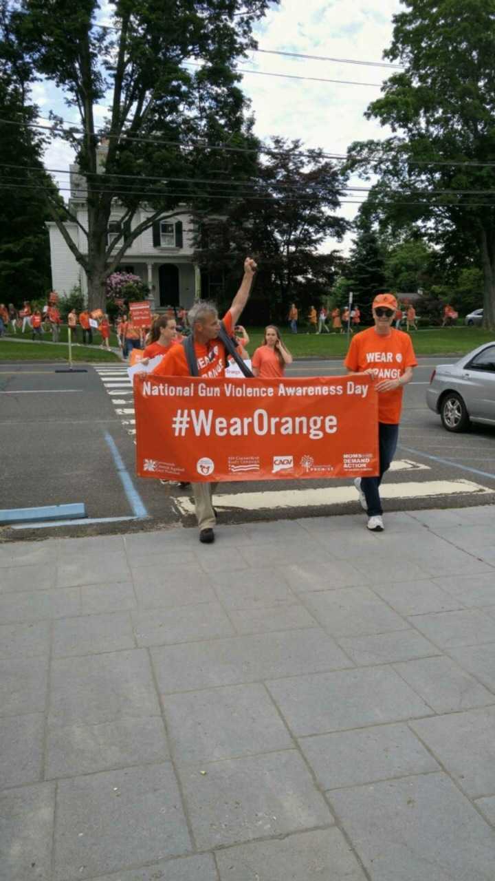 <p>The #WearOrange banner leads the marchers Thursday in Newtown.</p>