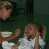 Demi Gagliardi feeds a child at an orphanage in Vietnam.