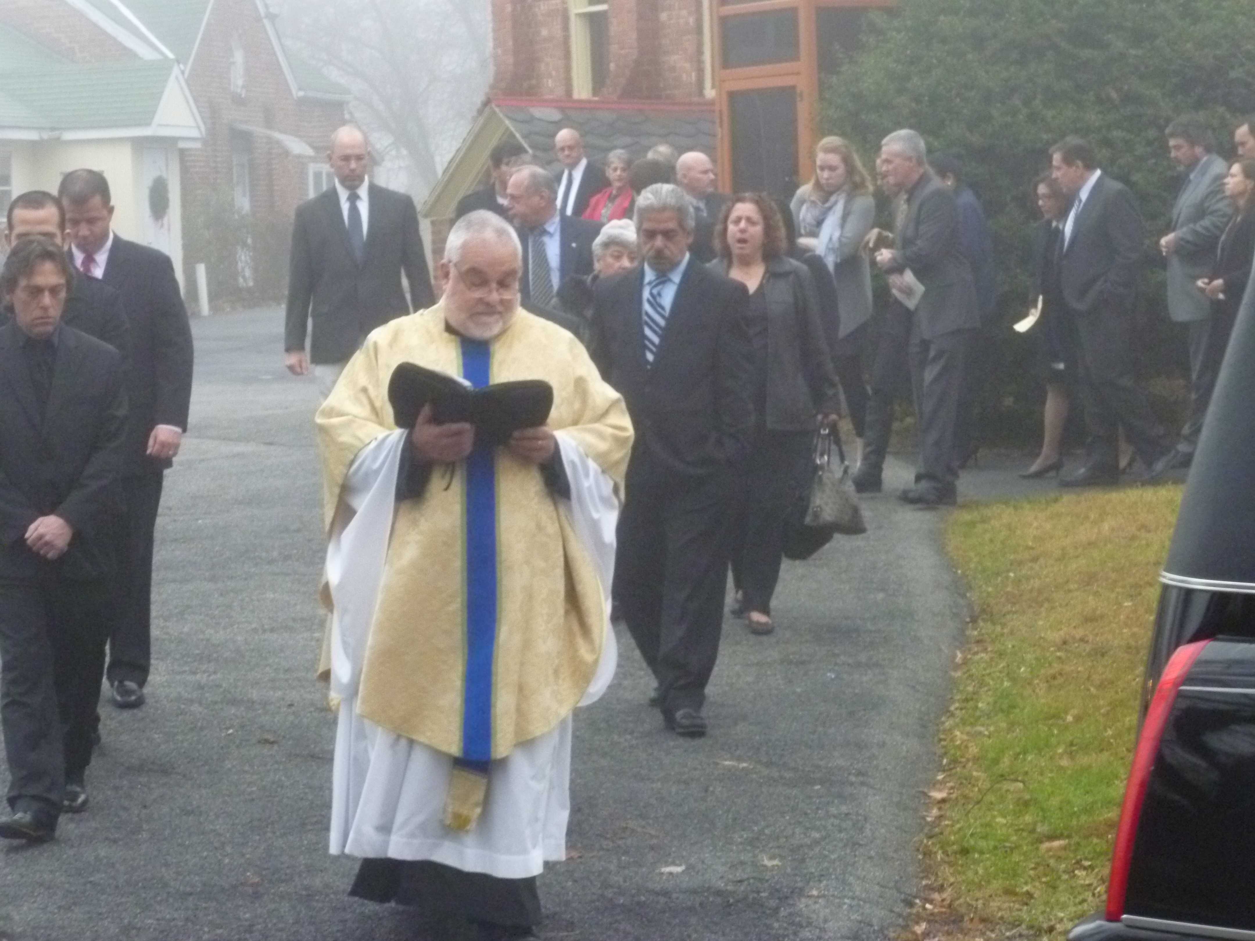 Rev. Eric Cosentino leads the procession at James Ferrari's funeral in Montrose. 