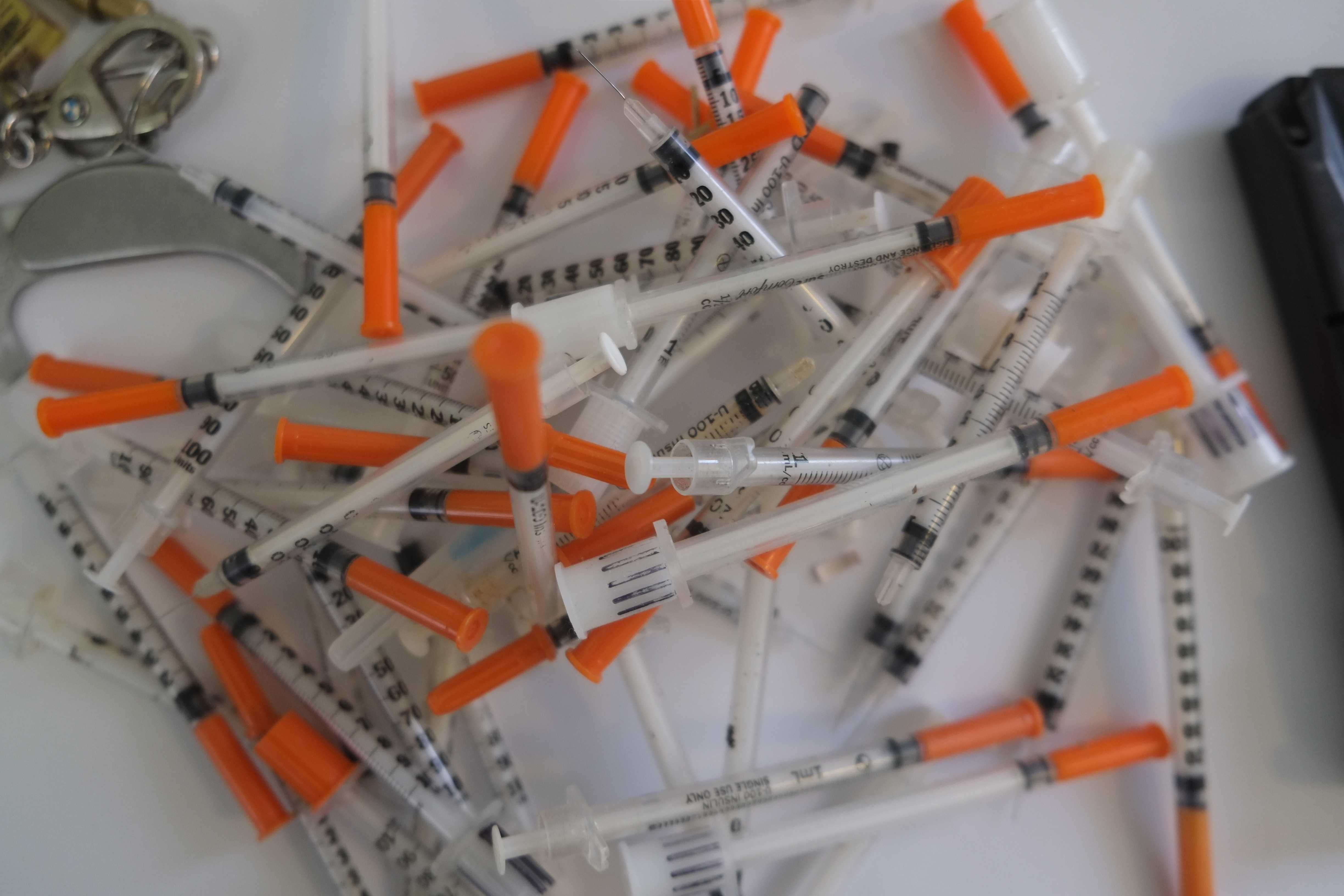 Police say they uncovered weapons and a large quantity of hypodermic needles, as well as heroin from Kyle Caruso's Pound Ridge home. 