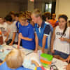 <p>Emily Salvino, right, signs in to volunteer at Helping Hands Annual Mission Backpack Event. </p>