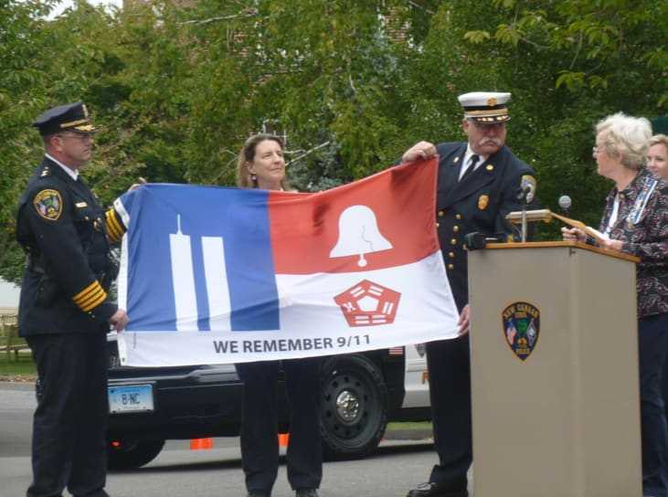 Diane Wells, right, regent of the Hannah Benedict Carter chapter of the Daughters of the American Revolution presents a flag to New Canaan first responders. Each part of the flag represents the three areas involved in the 9/11 attacks.