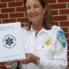Wendy Humboldt, captain of the New Canaan Volunteer Ambulance Corps, holds a book of 9/11 memories compiled by corps members.