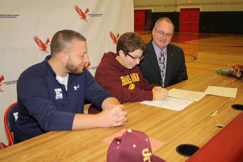 Katie Feigenbaum signs her commitment letter as Eastchester Athletic Director Jason Karol and Superintendent of Schools Walter Moran look on.