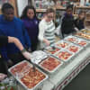 Students and a PTA member prepare to serve food.