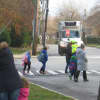 <p>A school crossing guard helping children cross safely with the traffic light at Osborn and Boston Post Roads. </p>