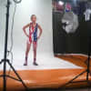 Myles Griffin stands in front of cameras in front in his wrestling singlet.