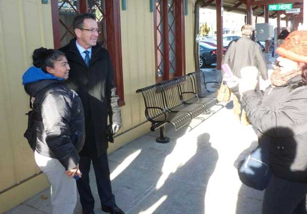 Gov. Dannel P. Malloy snaps a photograph with a couple of fans at the New Canaan train station Tuesday afternoon.