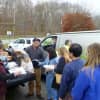 Sen. Greg Ball, center, helps distribute dry ice and water at the Lewisboro Town House on Tuesday as Town Clerk Janet Donohue, far left, looks on.