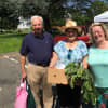 Shoppers Priscillia and John Woyke join Market Master Lexi Gazy for a picture at the New Canaan Farmers Market on Saturday.