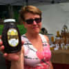 Beekeeper Patty Heyl, of Redding, holds up a bottle of honey at the Wilton sidewalk sale.