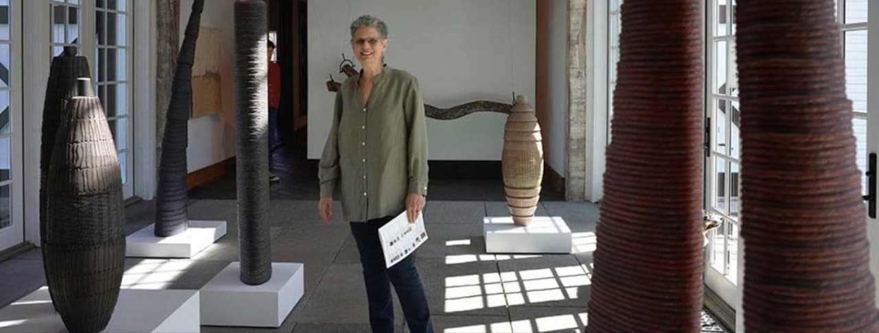 Artist Debra Sachs stands among six of her pieces being displayed during the ArtBoom at the BrownGrotta in Wilton.