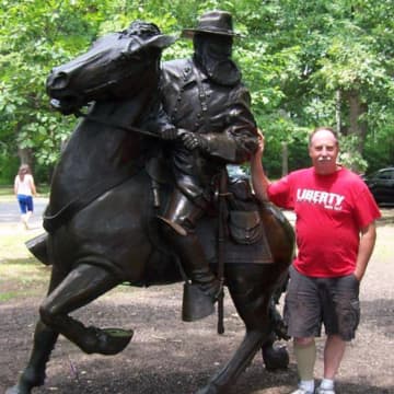 Tim Adriance -- here standing with a statue of his cousin, General James Longstreet, at Gettysburg -- will be honored with a lifetime achievement award for historic preservation.