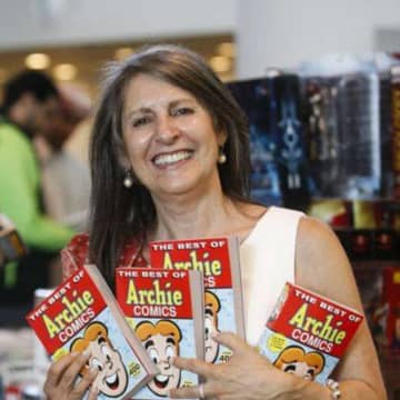 Nancy Silberkleit, publisher and co-CEO of Archie Comics, poses next to a sign proclaiming some of her comic book mottos.