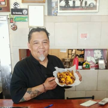 Rony Alvarado, owner of Bergenfield's Rony's Rockin' Grill, shows off the Disco Sucks fries.
