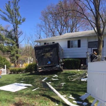 A large moving truck plowed into the front of a home.