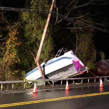 A boat being towed by a U-Haul box truck broke loose and slammed into a utility pole.