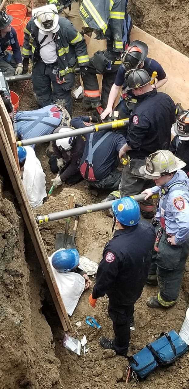 Two men were rescued after being trapped in 10-feet of dirt following a trench collapse.