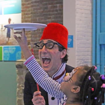 Comedian/juggler Peter Straus clowns with a young guest and a spinning plate during last year’s New Year’s Eve celebration at The Maritime Aquarium at Norwalk.