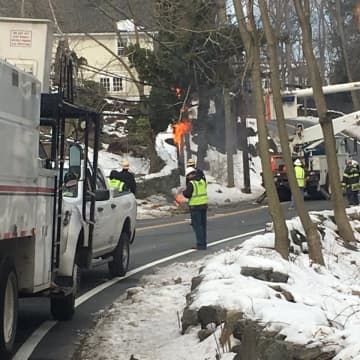 Glenville Road in Greenwich is closed late Tuesday morning with wires down and burning.