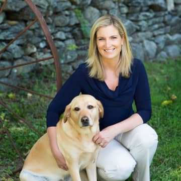 Jennifer Hill, the president of Wilton-based Canine Company, with her yellow lab, Chloe.