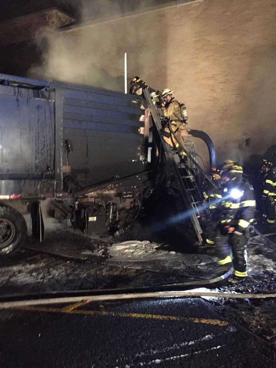 Firefighters put out a garbage truck fire in front of Robert E. Bell Middle School in Chappaqua.